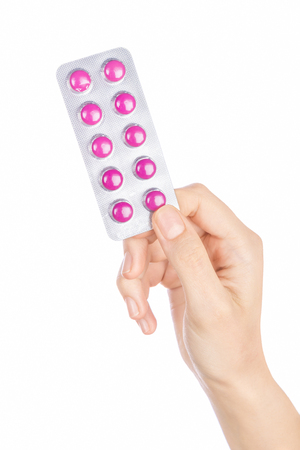 Woman hand holding pills tablet. Female hand holding prescription pill over white background.の写真素材