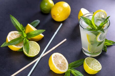 Cold refreshing summer lemonade with mint in a glass on a grey and black background. Focus on leaf in glass.の写真素材