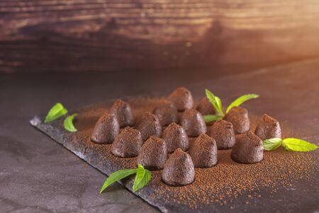 Homemade chocolate truffles with mint sprinkled with cocoa powder on slate. Focus on trufflesの写真素材