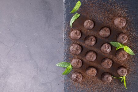 Top view of delicious chocolate truffles powdered with cocoa on slate. Focus on truffles.の写真素材