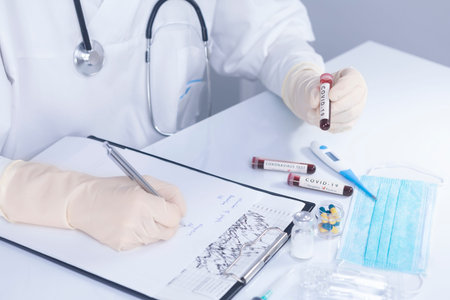 Doctor hands with protective gloves holding COVID 19 Coronavirus test blood making statistical...