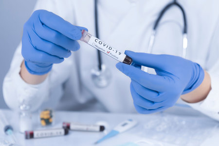 Doctor hands with protective gloves analyzing COVID 19 Coronavirus test blood. Virus test and...