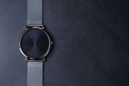 Black wrist watch for women with metal strap top view on gray background.の写真素材