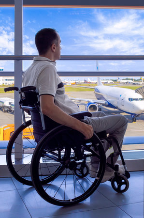 Young man in a wheelchair at the airport closeupの写真素材