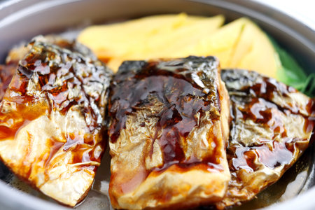 Pices of Saba fish grilled are on rice in bowl and teriyaki sauce on top, Thailand.