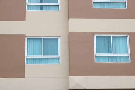 Aluminium frame and glass window of brown painted building with curtain inside.