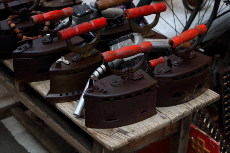 Retro charcoal black iron row on wood table in Thailand.の写真素材
