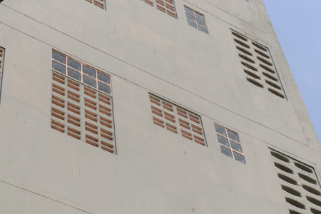 Row of glass block and concrete on outside wall of white building in Thailand.