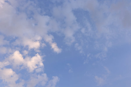 White clouds and light blue sky with sunlight on cloud.