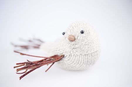 knitted gray bird, with branches instead of the wings and tail, white background, winter home decorationの写真素材