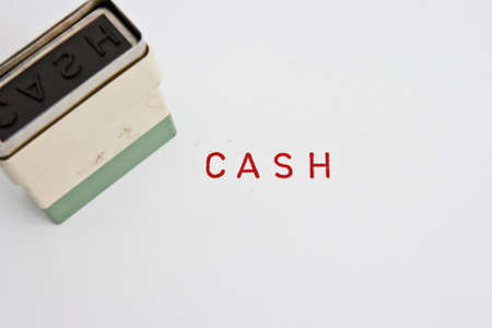 Old wooden rubber stamp soiled in red ink with the word cashの写真素材