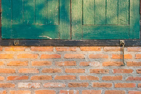 green window in a red brick wall の写真素材