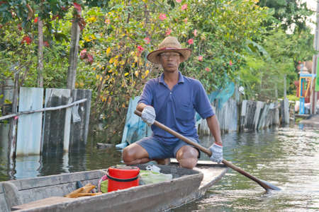 BANGKOK THAILAND - SEP 13:An unidentified man boat hire another people in 30 Baht. Flood event on Septemper 13,2011 Soi Raminthra 109, Bangkok Thailand のeditorial素材