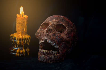 skull and candle in black background.の写真素材