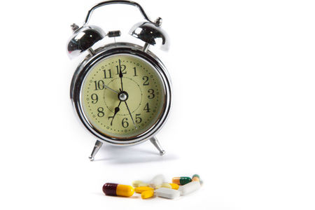 Drug pills and watches in white background.の写真素材