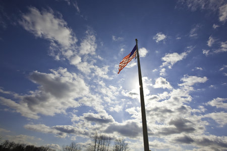 Against a beautiful blue sky and in a strong wind the Stars and stripes waves proudly