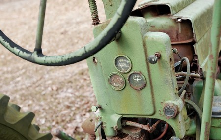 Weathered antique tractor showing steering wheel and gaugesの写真素材