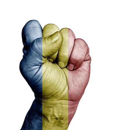 Low key picture of a fist painted in colors of romania flag の写真素材