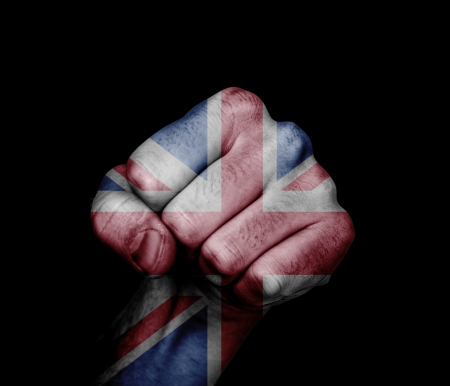 Low key picture of a fist painted in colors of united kingdom flag の写真素材