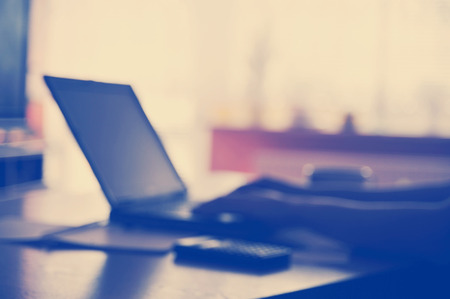 Modern business workplace with a laptop and some papers with charts, graphs and numbers on a desktop.の写真素材