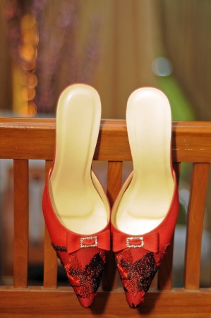 red bride shoes hanging on the chairの写真素材
