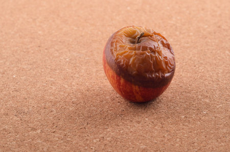 Wilted rotten apple on brown background.の写真素材
