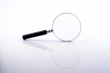 Magnifying glass in a metal frame with rubber black handle on white backgroundの写真素材