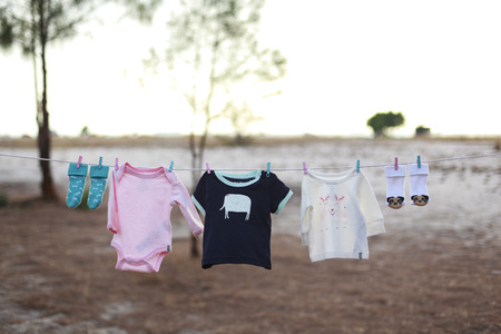 a pink and a baby blue T-shirt hanging on a clothesline on a beautiful, sunny day. shallow dof.の写真素材
