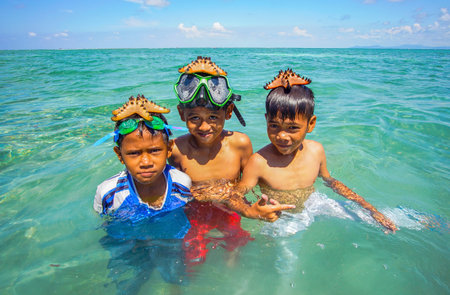 SABAH, MALAYSIA - NOVEMBER 19: Unidentified Bajau Laut kids hold a beautiful starfish at Maiga...