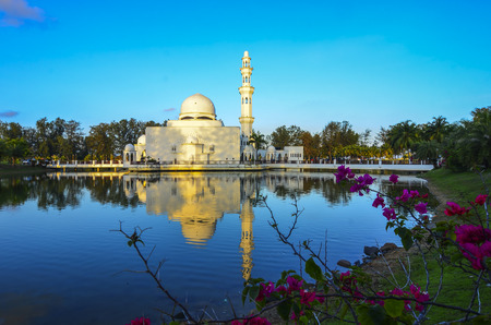 Beautiful white mosque with reflection in the lake during clean blue sky.の写真素材