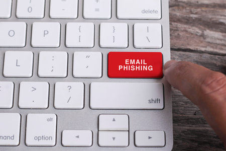 Close up of finger on keyboard button with EMAIL PHISHING word