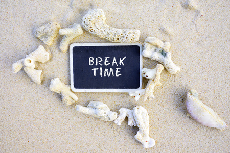 BREAK TIME handwritten on framed blackboard at sandy beach.の写真素材