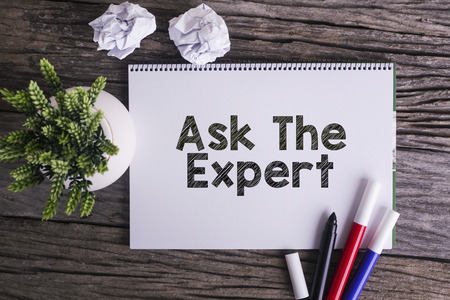 Notepad and green plant on wooden background with Ask The Expert wordの写真素材