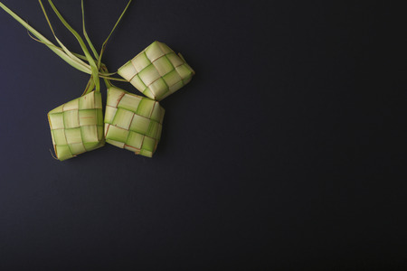 Ketupat (Rice Dumpling) On Black Background. Ketupat is a natural rice casing made from young coconut leaves for cooking rice during eid Mubarakの写真素材