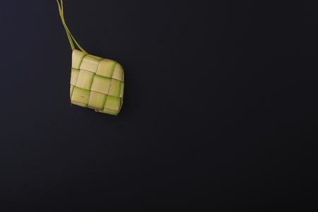 Ketupat (Rice Dumpling) On Black Background. Ketupat is a natural rice casing made from young coconut leaves for cooking rice during eid Mubarakの写真素材