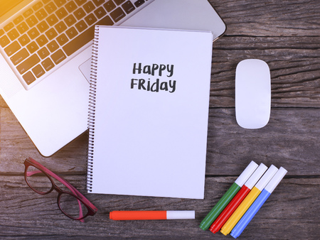 Notebook writing Happy Friday, Office table with laptop ,coffee cup,glassesの写真素材