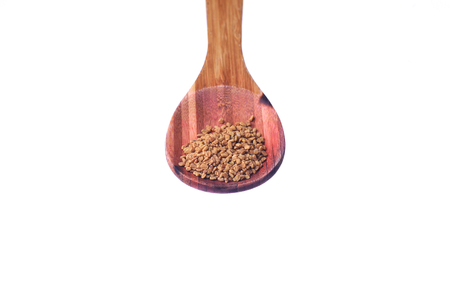 Fenugreek seeds on a brass spoon isolated on a white backgroundの写真素材