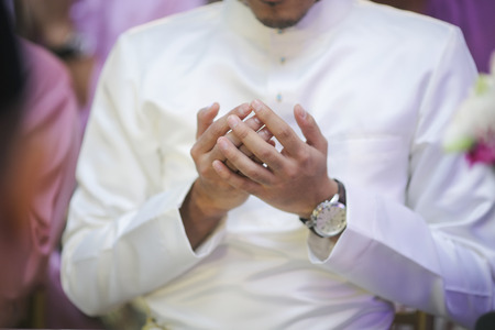 GROOM PUT HIS HAND TO PRAY DOAの写真素材