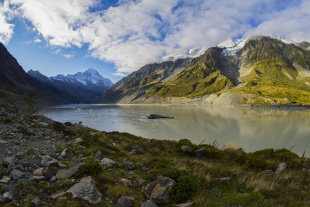Tasman Glacier Lake with giant floating icebergs, Aoraki Mount Cook National Park New Zealand. Mt Cook looming in the cloudsの写真素材