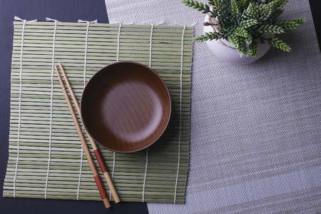 Wooden bowl and a pair of chopstick on bamboo backgroundの写真素材