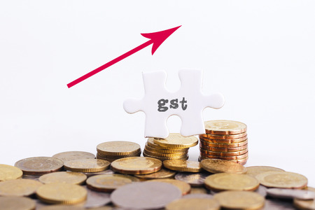 GST word on White missing puzzle and gold coins with copyspace areaの写真素材
