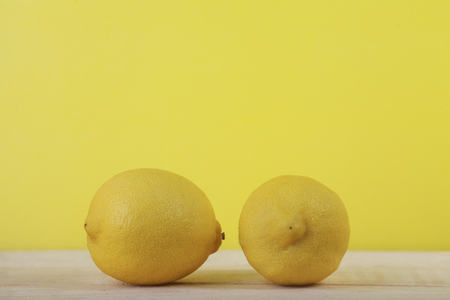 Fresh lemon fruit on wooden and yellow backgroundの写真素材