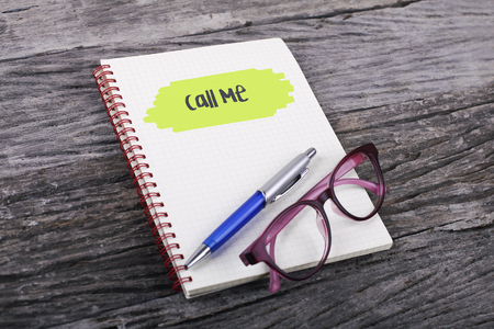 Note with call me on the wooden backgroundの写真素材