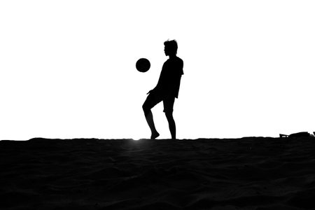 Silhouette of a man playing footballの写真素材
