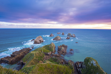 Beautiful and dramatic long exposure shot of sunrise At Nugget Point lighthouse, Caitlins, south Island of New Zealandの写真素材