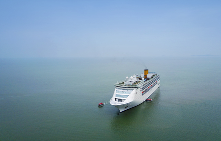 White luxury cruise ship docked in beautiful Caribbean sea close to the beachの写真素材