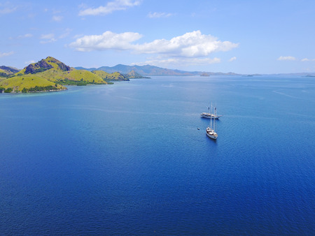 Aerial view of beautiful scenery at Flores island with tourist yatch, turqouise and dark blue seaの写真素材