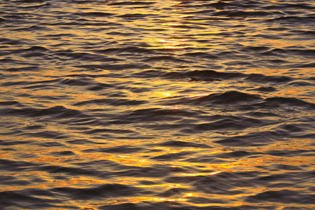 Water ripple on the sea during golden sunsetの写真素材