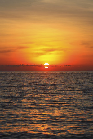 An image of a nice red sunset with a big yellow sunの写真素材