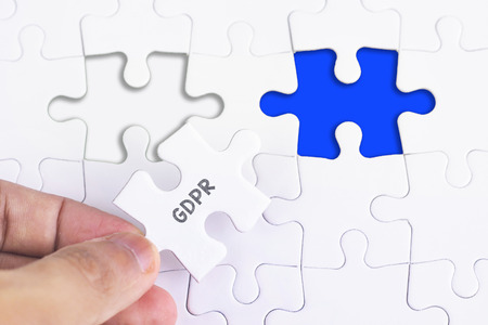 Business Concept - Female hand and missing puzzle with GDPR WORDの写真素材